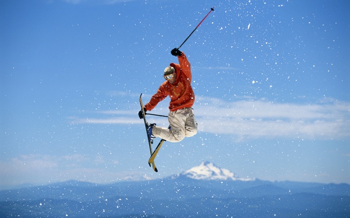 Skier performing a jump with snow falling