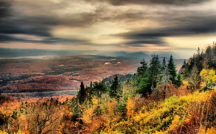 Autumn mountain landscape with distant lakes and stormy sky