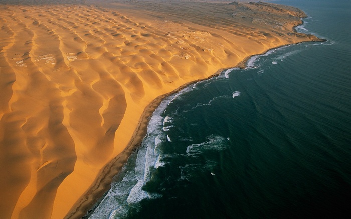 Namib Desert dunes meet the Atlantic Ocean