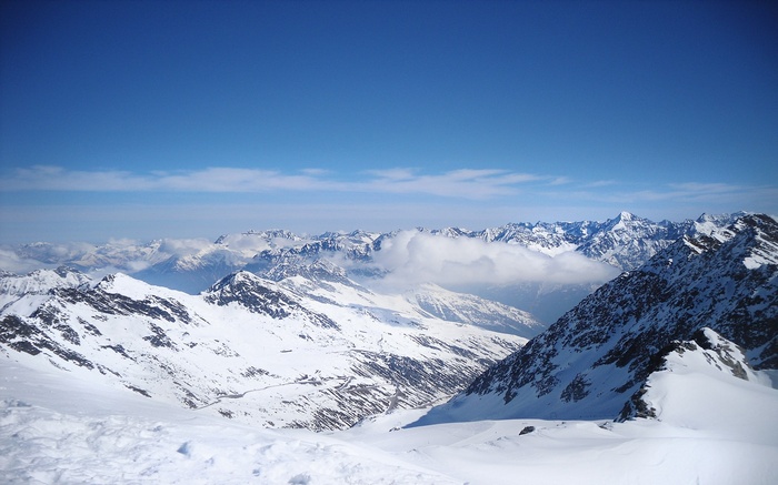 Snow-covered mountains under a clear blue sky