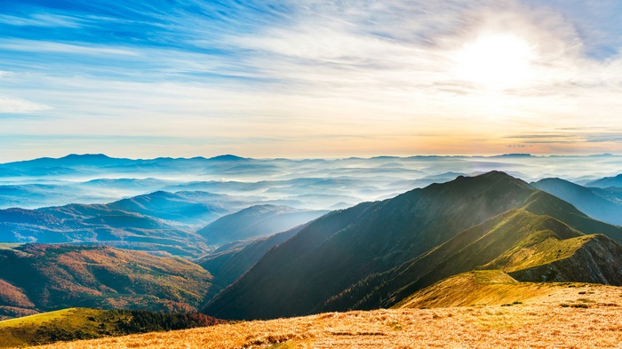 Mountain landscape with sun and clouds