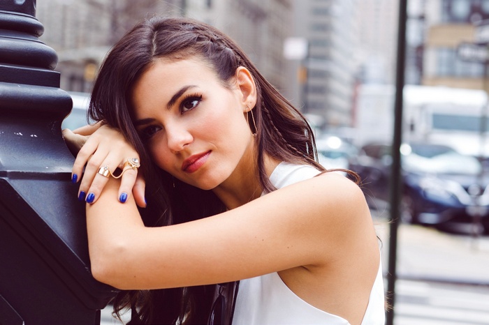 Victoria Justice leaning on a lamppost in New York City