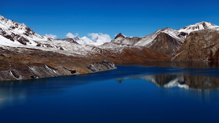Snowy mountains reflected in a blue lake