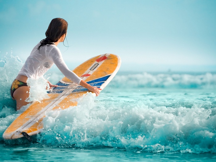 Woman with surfboard in the ocean