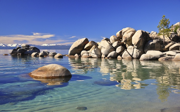 Lake Tahoe with Boulders and Snow-Capped Mountains