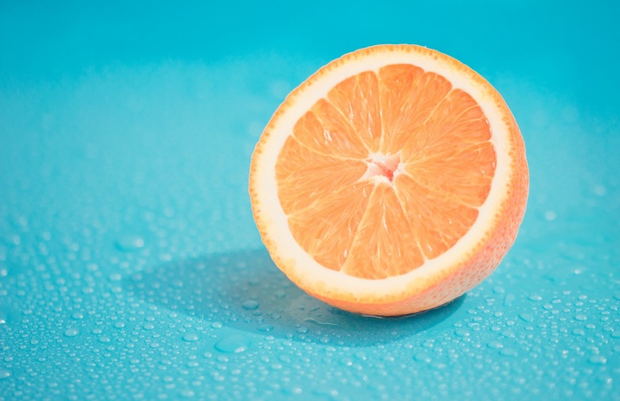 Half orange on a wet blue surface