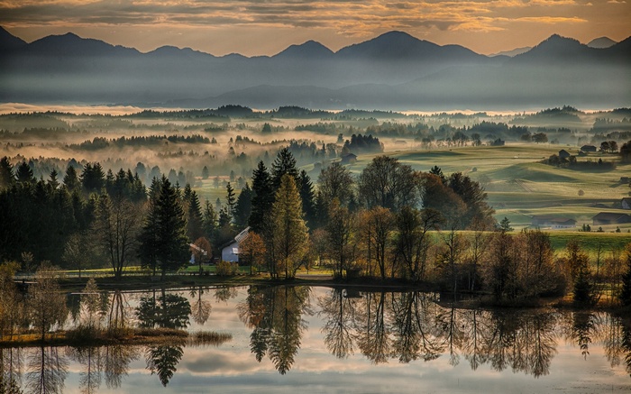 Misty mountain landscape with a lake and trees
