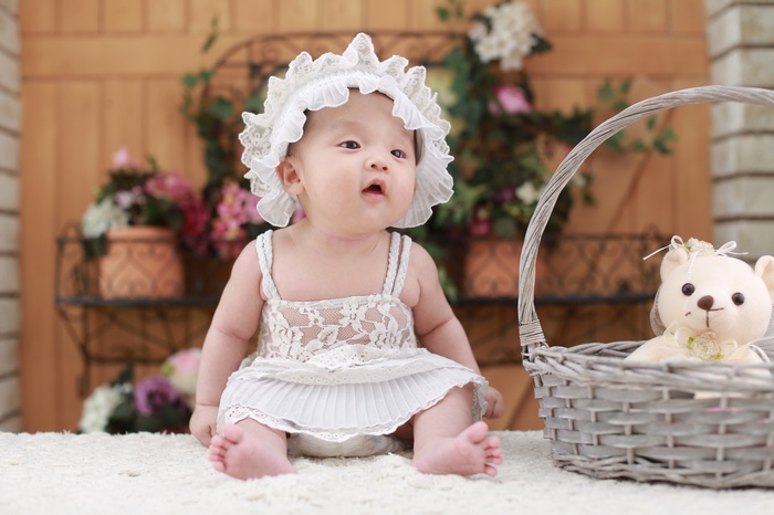 Baby girl with teddy bear in a basket