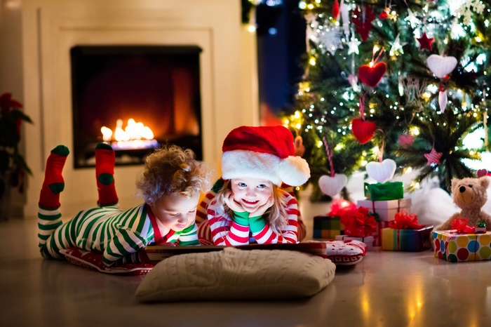 Christmas scene with kids by fireplace and tree