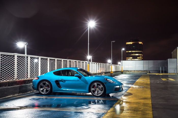 Blue Porsche Cayman S on wet parking lot at night 4K