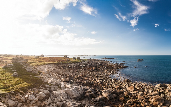 Rocky coastline with a lighthouse in the distance