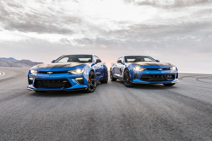Two blue Chevrolet Camaros on a road