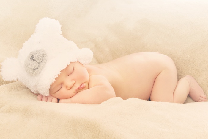 Newborn baby sleeping in a bear hat
