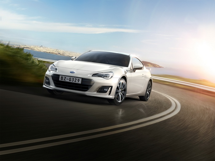 White Subaru BRZ driving on a coastal road