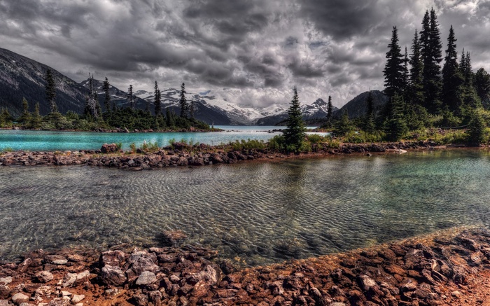 Turquoise lake and mountains under cloudy sky