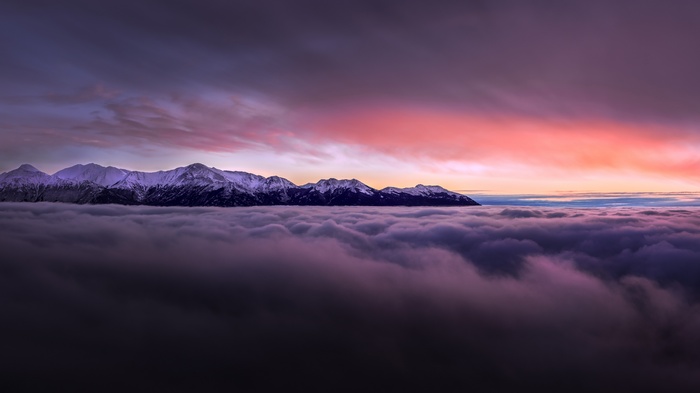 Snowy Mountains Above Clouds at Sunset Panorama
