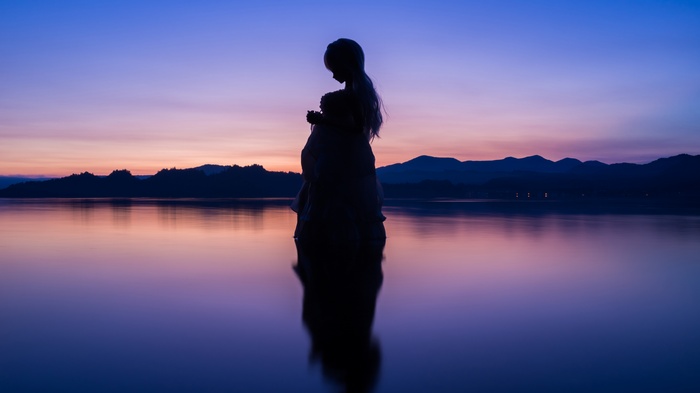 Silhouette of a girl at Lake Towada at dawn