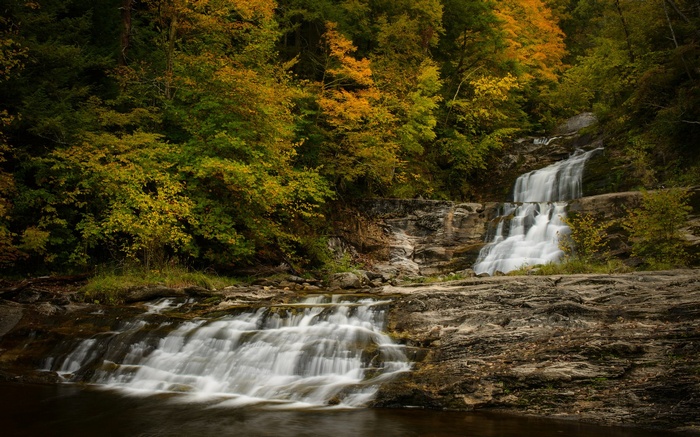 Waterfall cascading through autumn forest