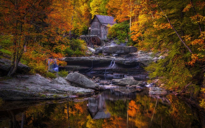 Old mill by a waterfall in autumn
