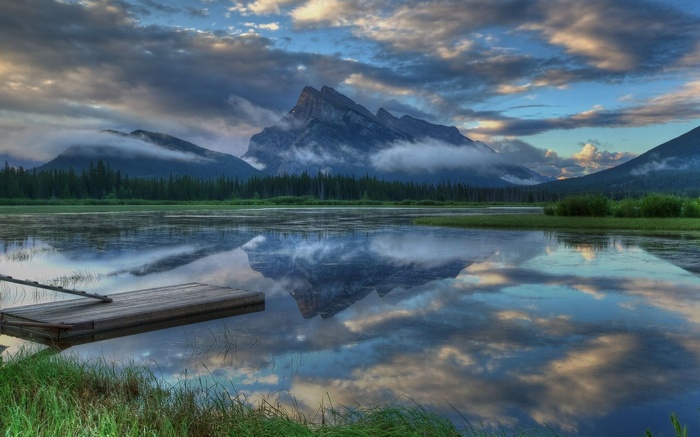 Mountain reflected in a lake with a wooden dock