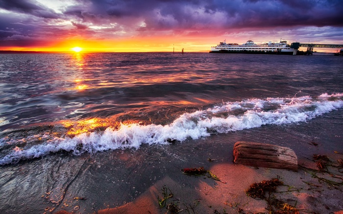 Ferry docked at sunset with waves on the shore