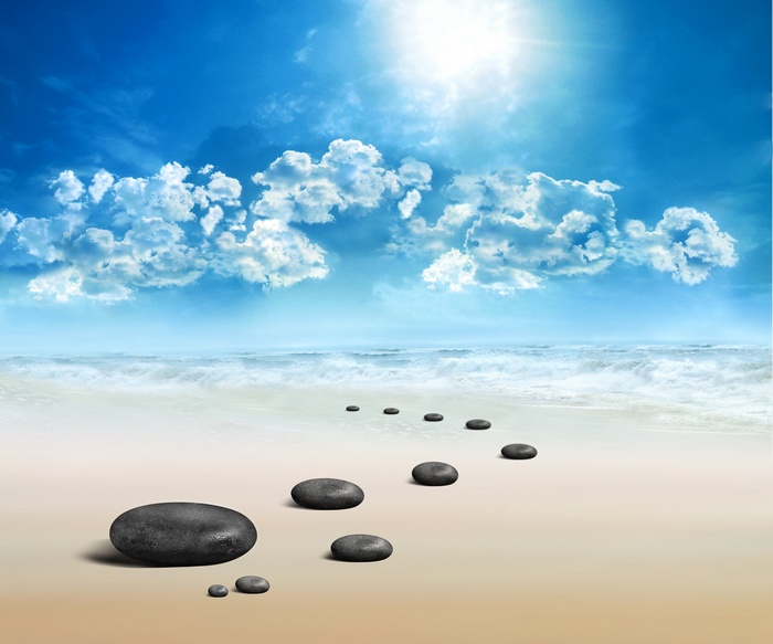Stepping stones on a beach under a sunny sky