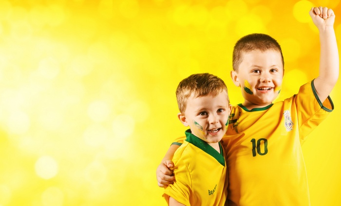 Two young boys in Brazil soccer jerseys with face paint