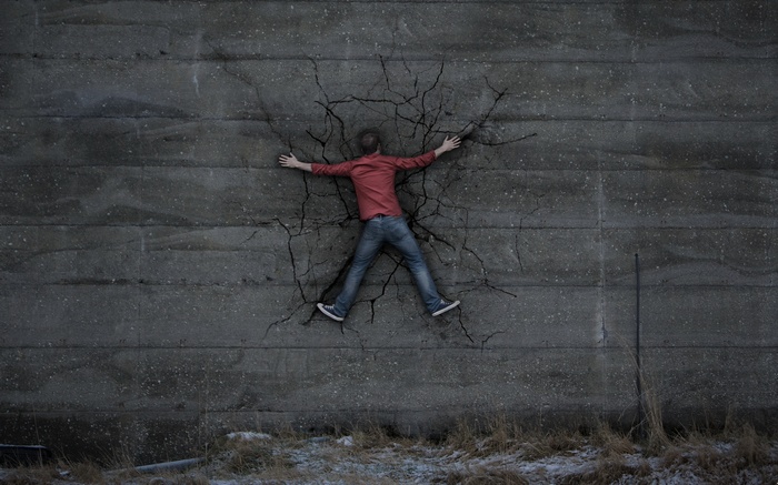 Man stuck in a cracked concrete wall
