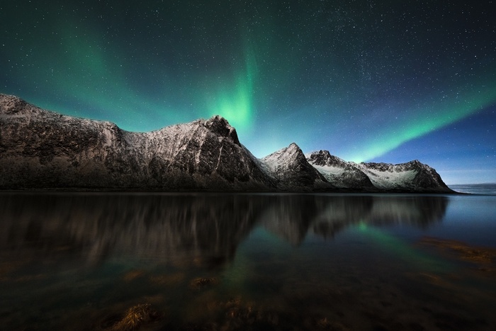 Aurora Borealis over Snow-Capped Mountains and Reflecting Water