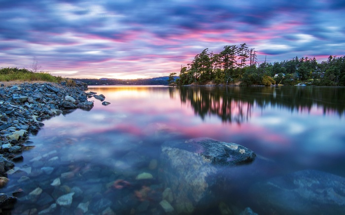 Sunset over a rocky shore and calm lake