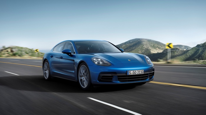 Blue Porsche Panamera driving on a scenic road