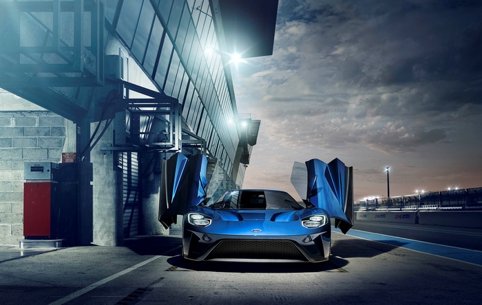 Blue Ford GT with doors open on a racetrack