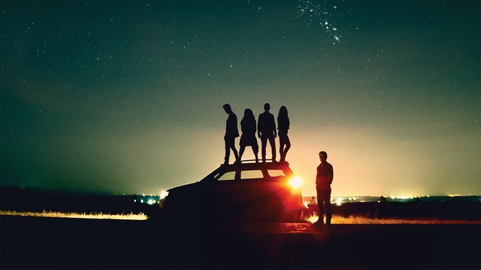 Power Rangers standing on a car at night