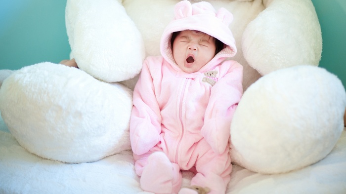 Asian baby yawning in pink bear costume