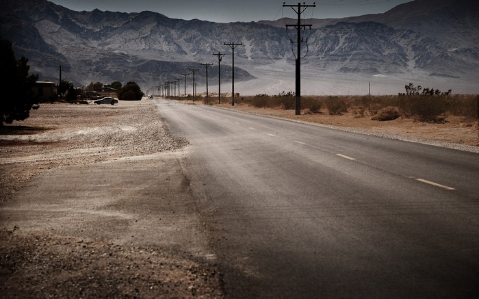 Desert road with mountains and power lines