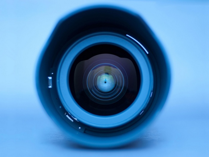 Close-up of a camera lens with blue lighting