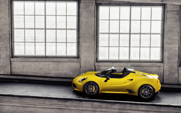 Yellow Alfa Romeo 4C Spider parked indoors