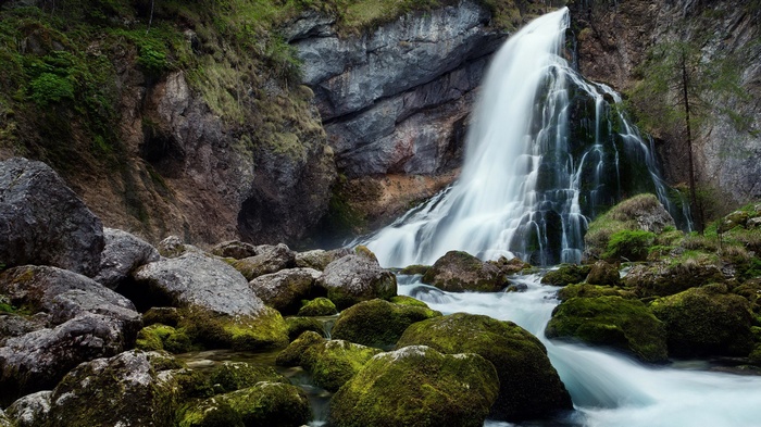 Waterfall cascading over mossy rocks in a forest
