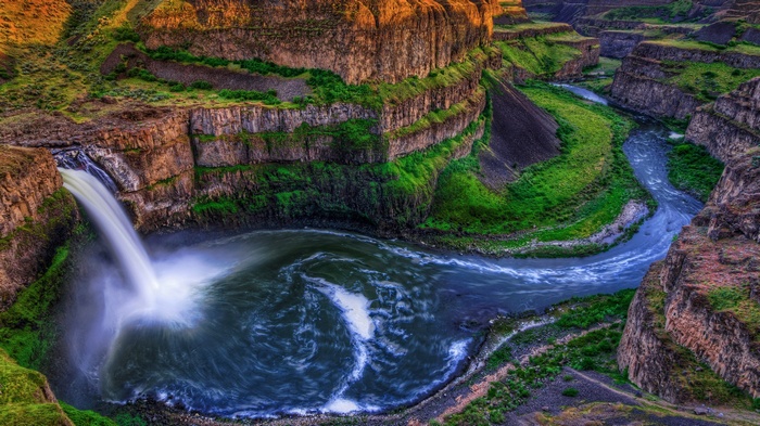 Waterfall cascading into a canyon river