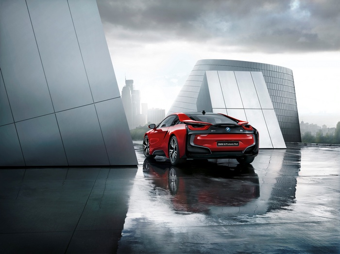 Red BMW i8 Protonic Red Edition parked near modern architecture