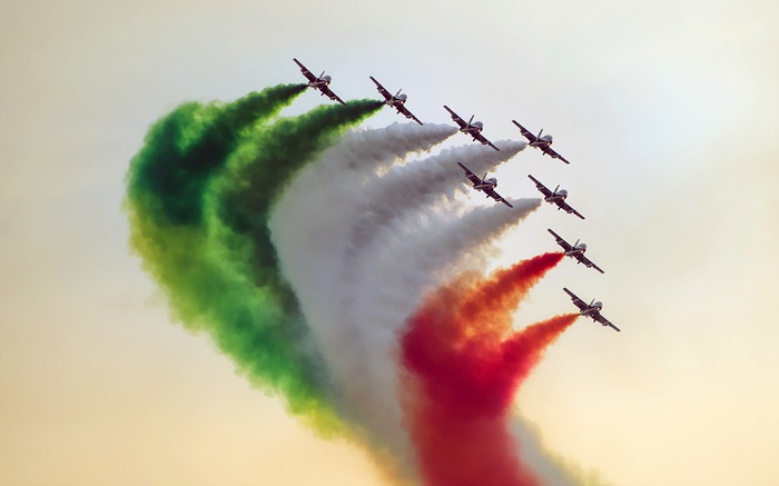 Fighter jets performing aerial maneuvers with colored smoke
