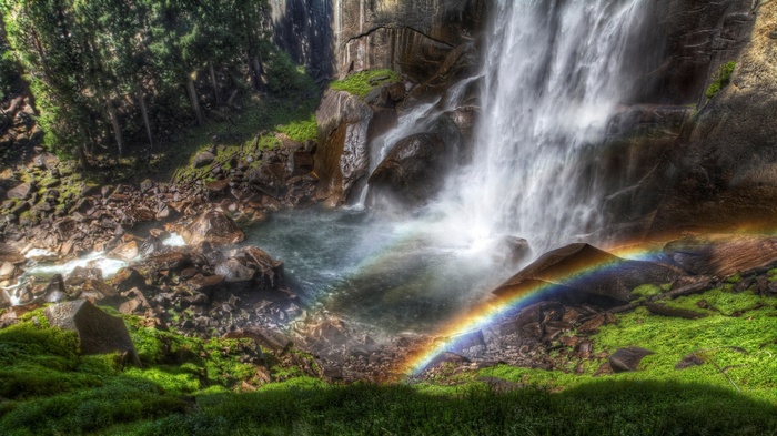 Waterfall with a rainbow and lush green surroundings
