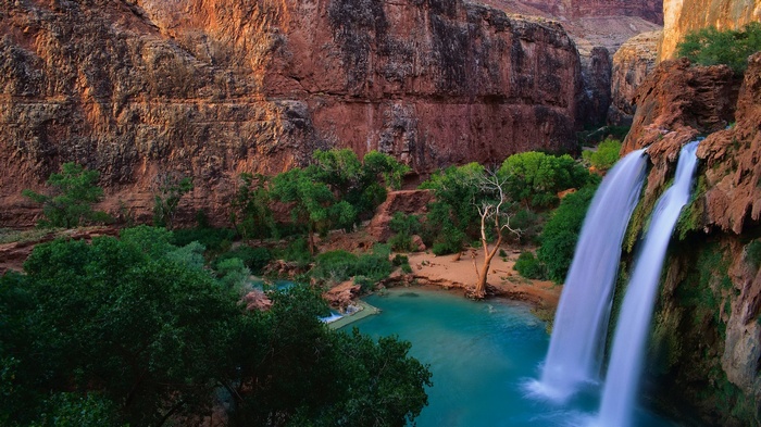 Waterfalls cascading into a turquoise pool in a canyon