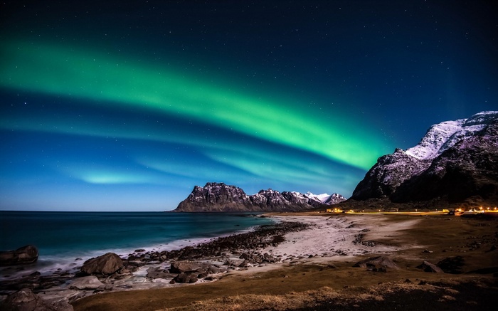 Aurora Borealis over a rocky beach and mountains