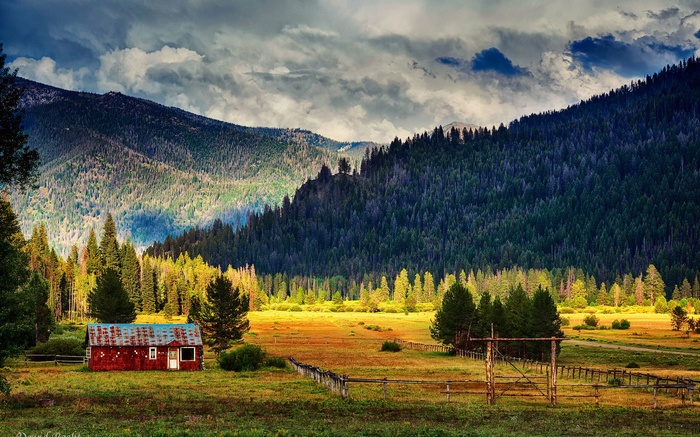 Red barn in a mountain valley with forest