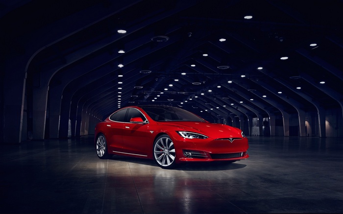 Red Tesla Model S P90D in a dark hall