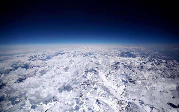Aerial view of snow-capped mountains and clouds