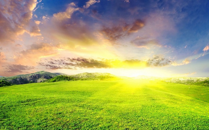 Sunrise over green hills and clouds