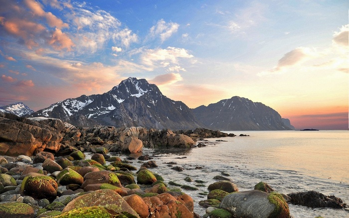 Rocky coastline with mountains at sunset
