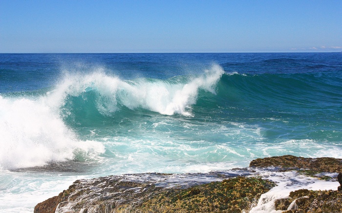 Ocean wave crashing on rocky shore